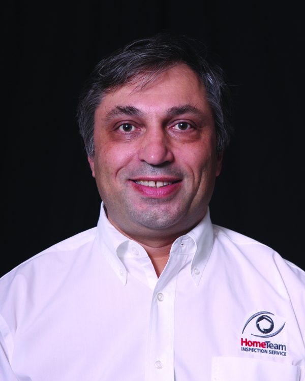 Professional headshot of Victor Glauberman smiling and wearing a white button-down shirt featuring the HomeTeam Inspection Service logo.